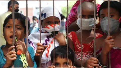 Getty Images Kids in a slum area in Gurugram wearing masks as precautionary measures over the spread of the COVID-19 novel coronavirus on the outskirts of New Delhi, India on 24 April 2020.