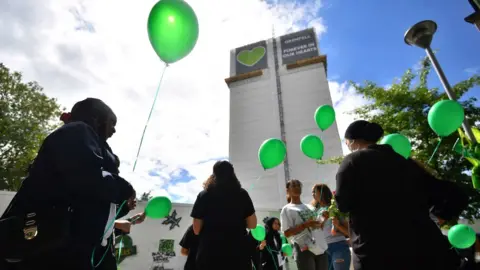 PA Media People released balloons at the base of the tower block on the third anniversary of the fire