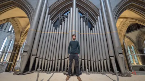 Ash Mills John Challenger in front of the organ