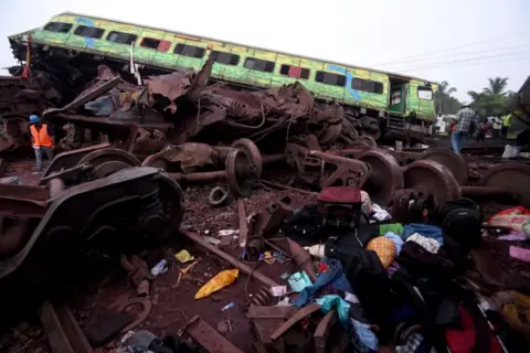 Reuters Belongings of passengers lie next to a damaged coach after a deadly collision of trains, in Balasore district, in the eastern state of Odisha, India, June 3, 2023