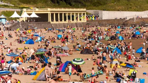 Getty Images People sunbathing on the beach in Barry