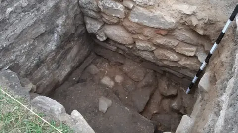 Dig Alderney Roman courtyard visible at bottom of trench