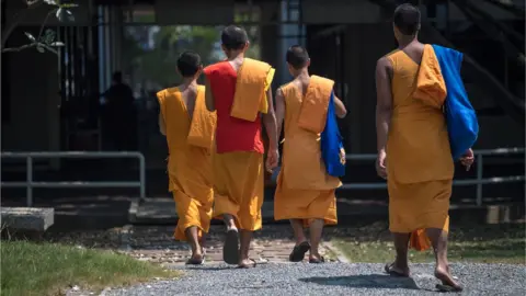 Getty Images Buddhist monks enter the Wat Dhammakaya temple grounds, north of Bangkok, 1 March 2017