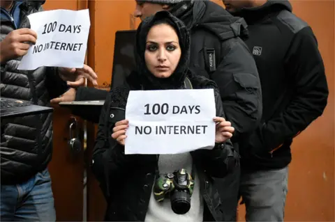 AFP A Kashmiri journalist hold a placard during protest against the continous internet blockade for 100th day out Kashmir press club , Srinagar, Indian Administered Kashmir on 12 November 2019.