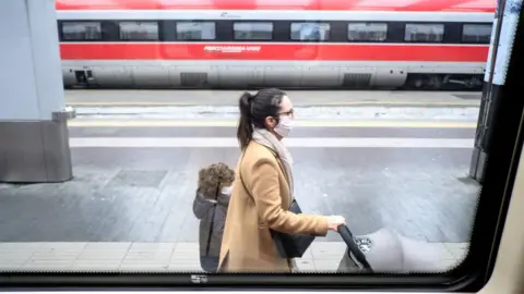 AFP Passengers at the main station in Milan are now wearing face masks