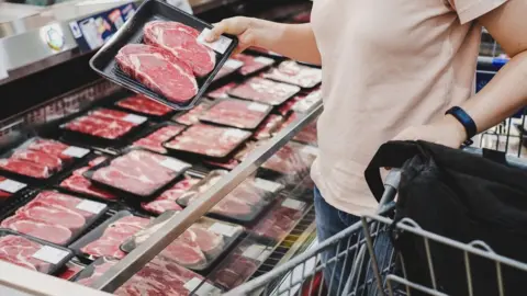 Getty Images Woman shopping at meat section in supermarket.