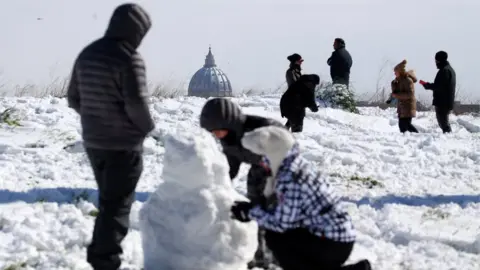 Reuters St Peter's Basilica is seen in the background as people enjoy the snow at the Circus Maximus in Rome