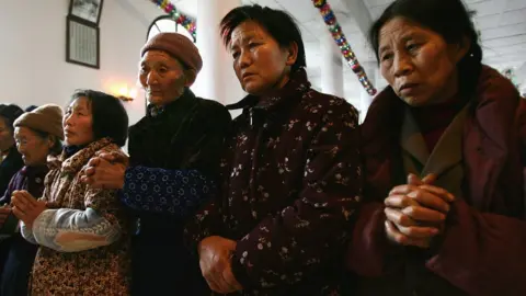 Getty Images Women worship at a state-sanctioned Catholic church in Sichuan (file image)