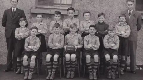 Judith Gates Old black and white picture of young footballer players posing in rows