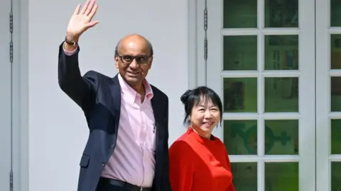 Getty Images Presidential candidate Tharman Shanmugaratnam (L) and his wife Jane Ittogi waves as he arrives at the nomination centre for the presidential election in Singapore on 22 August 2023.