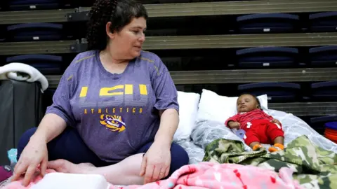 Reuters Louisiana evacuee Denise Vital, with her three-month-old godson, says her home was destroyed before, in 2005's Hurricane Rita