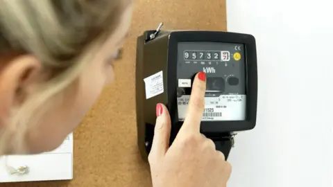 Getty Images Woman checks energy meter