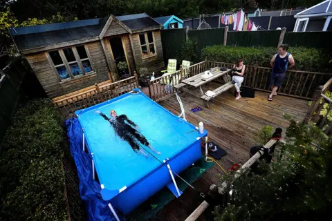 Carl Recine Triathlete Lloyd Bebbington trains in a pool in his garden at home