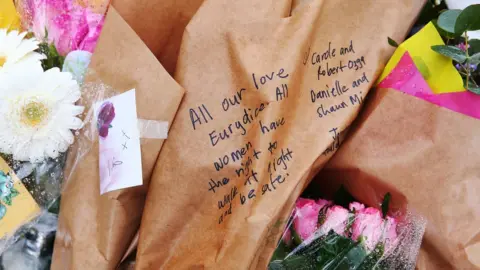 Getty Images A message on a bouquet tribute reads: "All our love Eurydice. All women have the right to walk at night and be safe."