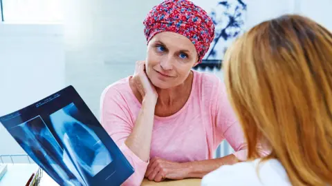 Science Photo Library A doctor and woman with cancer