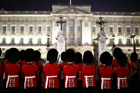 Henry Nicholls / Reuters Soldiers stand outside Buckingham Palace, as part in a full overnight dress rehearsal of the Coronation Ceremony.