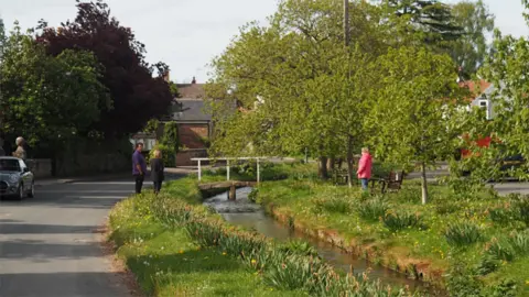 Villagers talking across beck