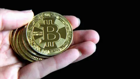 Getty Images A hand holding Bitcoin.