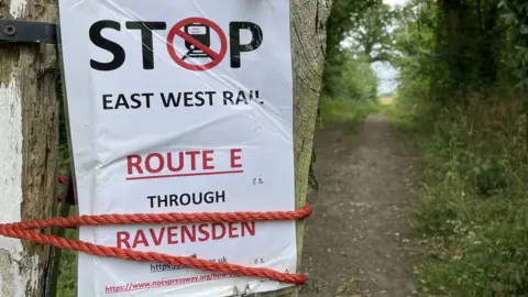 A Stop East West Rail poster in Ravensden, Bedfordshire