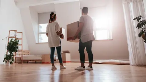 Getty Images young couple carrying cardboard box