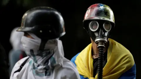 Reuters Demonstrators look on while rallying against the government in Caracas, Venezuela, 4 August