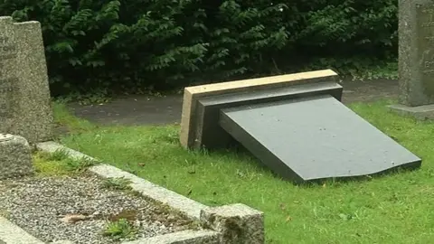 A gravestone lies face down