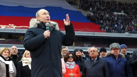 Getty Images Russian President Vladimir Putin speaks during a campaign concert in March 2018