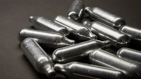 Getty Images Nitrous oxide is sold in metal canisters often discarded in the street