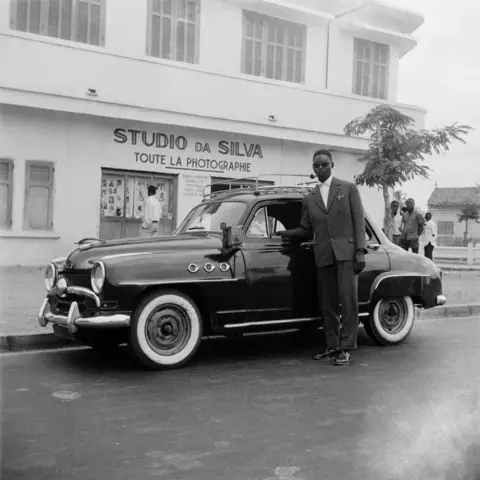 Roger DaSilva/Josef and Anni Albers Foundation A sharply dressed chauffeur poses with his vehicle outside Roger DaSilva's studio.