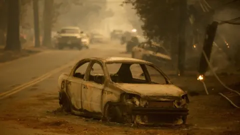 EPA Abandoned and burned out car on side of the road