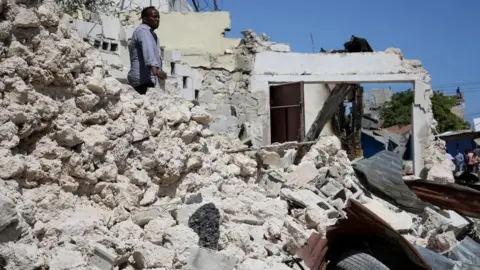 Getty Images A view of damage at the scene after a suicide car blast targeted a security convoy in Mogadishu, Somalia on January 12, 2022