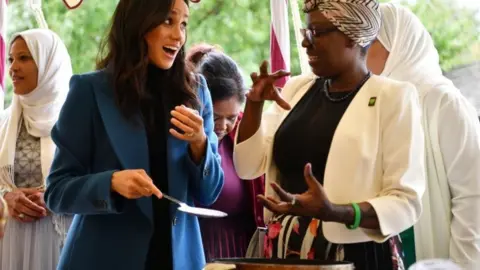 PA Meghan Markle holding spoon