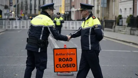 PA/Niall Carson Garda Commissioner Drew Harris (right) meets officers outside Leinster house