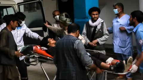 EPA People carry an injured man into a hospital after an explosion in downtown Kabul, Afghanistan, 08 May 2021.