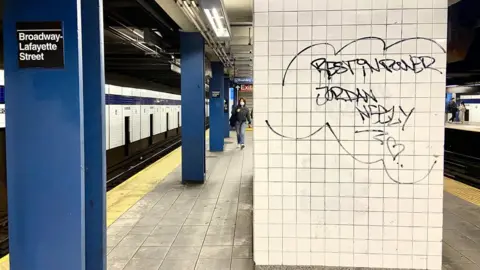 Kayla Epstein/BBC News Graffiti reading, "rest in power, Jordan Neely" scrawled in the station where police responded to the incident.