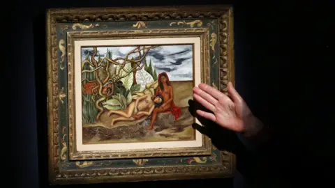 Getty Images An Art specialist at Christie's speaks about the artwork 'Dos desnudos en el bosque (La Tierra Misma)' made by artist Frida Kahlo during a press preview on April 29, 2016, in New York.