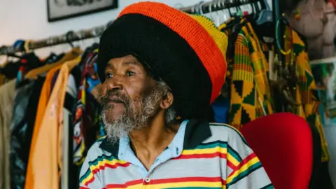 Khali Ackford Ras Bandele Selassie wearing red, yellow and green clothing