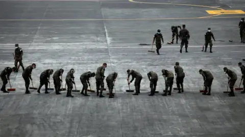Reuters Soldiers sweep the ash covered tarmac at La Aurora International Airport
