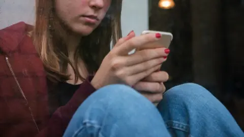 Getty Images Woman looking at phone