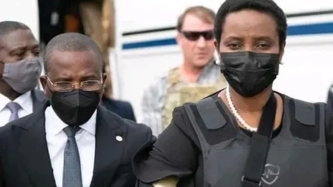 Reuters Interim Prime Minister Claude Joseph walks with the Haiti's first lady Martine Moïse