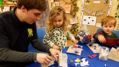 Daniel Harris, nursery worker doing art with children