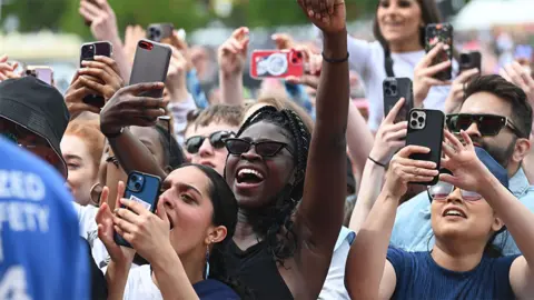 Fans taking pictures of performances