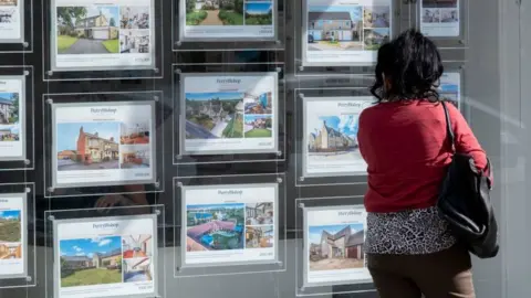 Getty Images Person looking in estate agent window