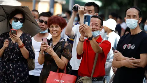 Reuters People taking pictures with their smartphones