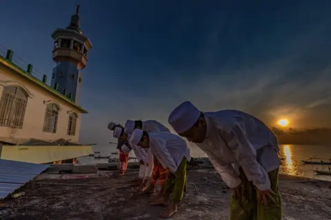 Robertus Pudyanto / Getty Images A large group of Indonesian Muslims pray at Al-Mabrur mosque in Surabaya, Indonesia