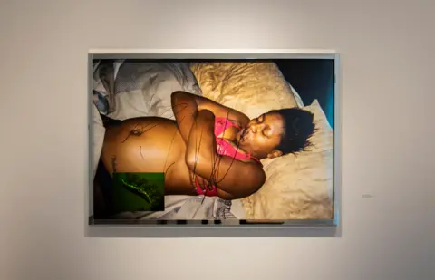 Deana Lawson Framed photo of a woman lying down with her arms crossed