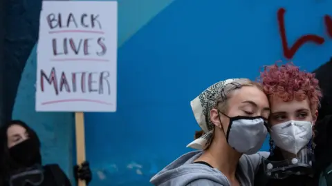 Getty Images Demonstrators hold a rally and teach-in outside of the Seattle Police Departments East Precinct, which has been boarded up and protected by fencing, on June 8, 2020 in Seattle, Washington.
