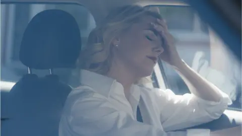 Getty Images An upset woman in a car