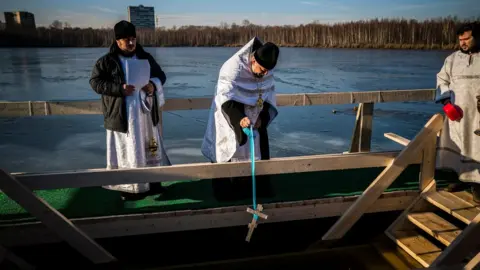 AFP An Orthodox priest blesses water in Svyatoye, in the outskirts of the Russian capital Moscow