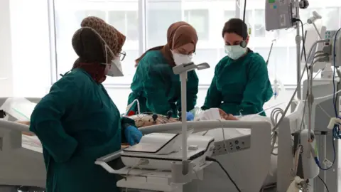 AFP Three masked medical workers tend to a patient in an intensive care unit in Ankara